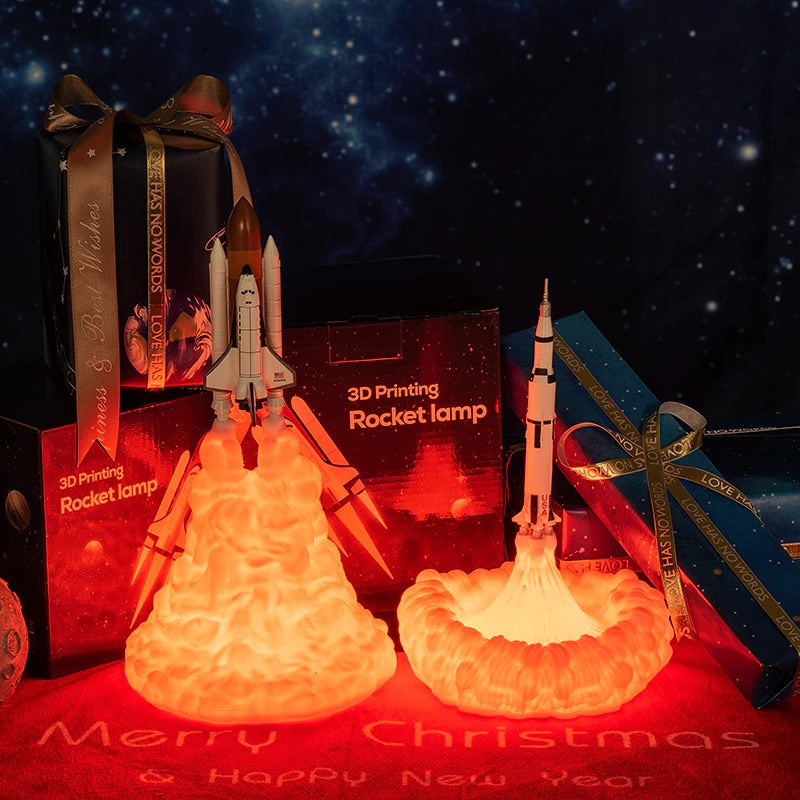 Two rocket ship night lights. Both rockets look like they are taking off with smoke behind them which is an orange glow.
