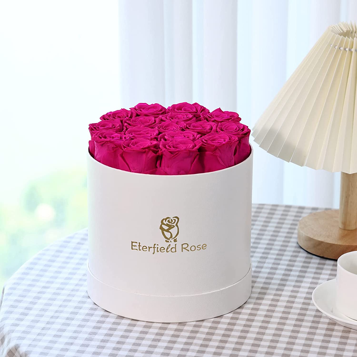 A white display box filled with 16 pink colored roses. These are roses that last for a year.