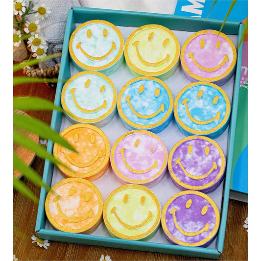 A 12-piece shower steamer aromatherapy shower bomb set. Each shower bomb has a smiley face on it.