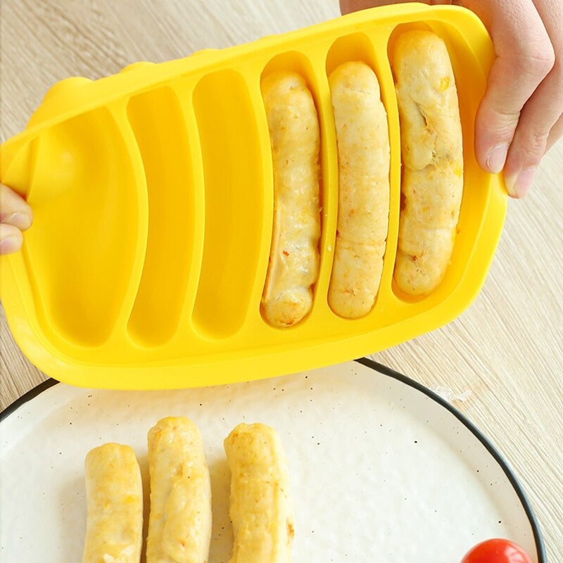 A yellow sausage mold maker with a pair of hands squeezing out already cooked sausages from the mold.
