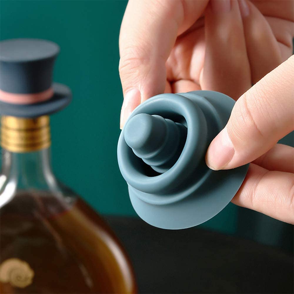 A close up view of a silicone wine stopper. A hand is turning the stopper inside out to show how the stopper plug looks underneath.