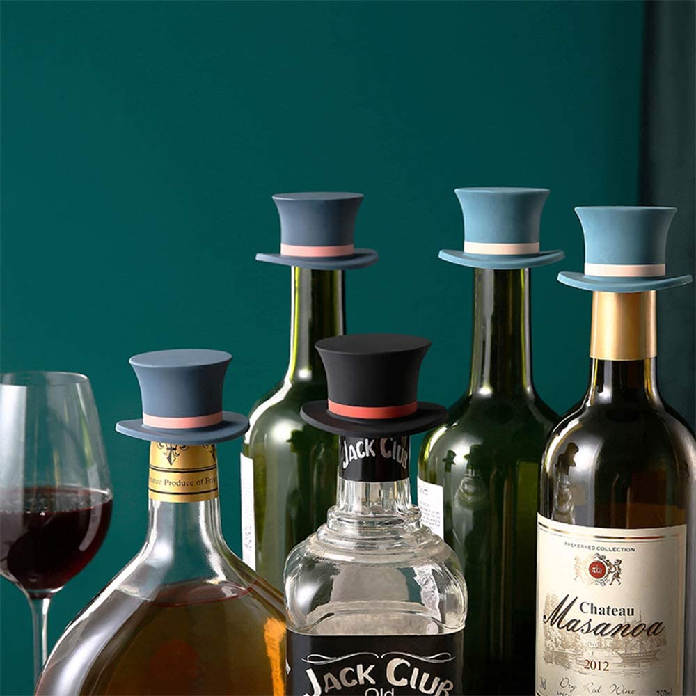 Five different colored silicone wine stoppers shaped as top hats on top of five bottles of alcohol.
