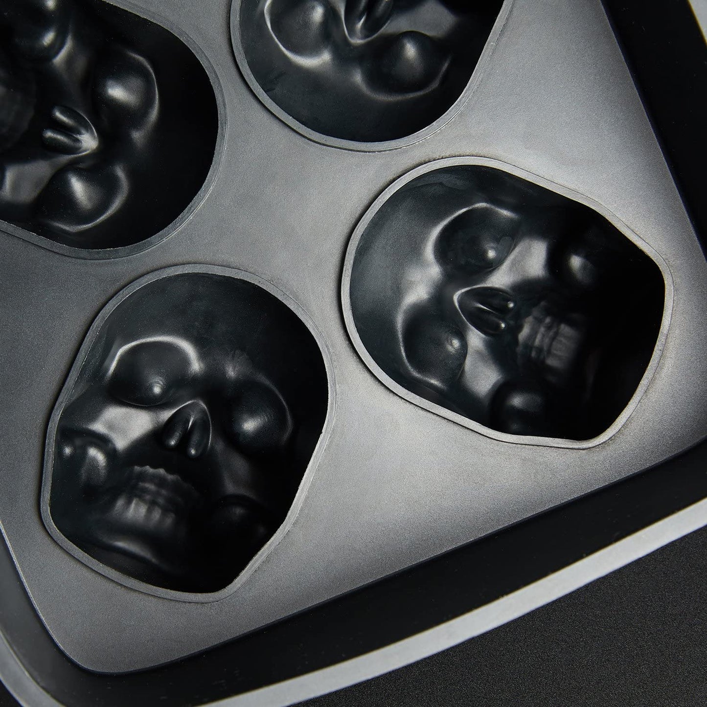 A close-up view of a black silicone food grade skull ice cube mold tray showing the skulls of the mold close-up.