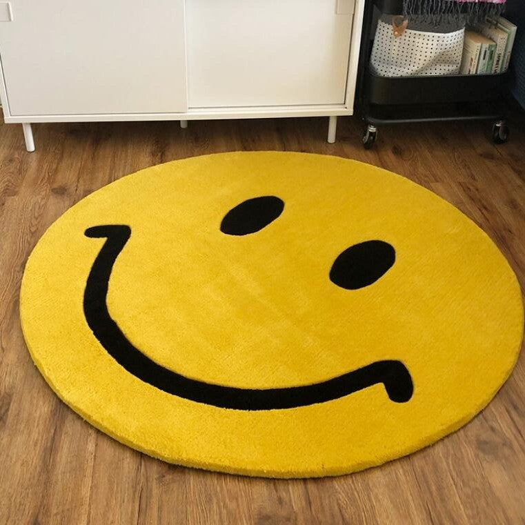 A large sized rug in a shape of a smiley face emoji.