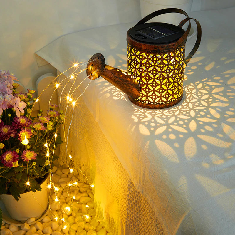 A cute solar powered watering can with a flow of fairy lights coming out of the spout.