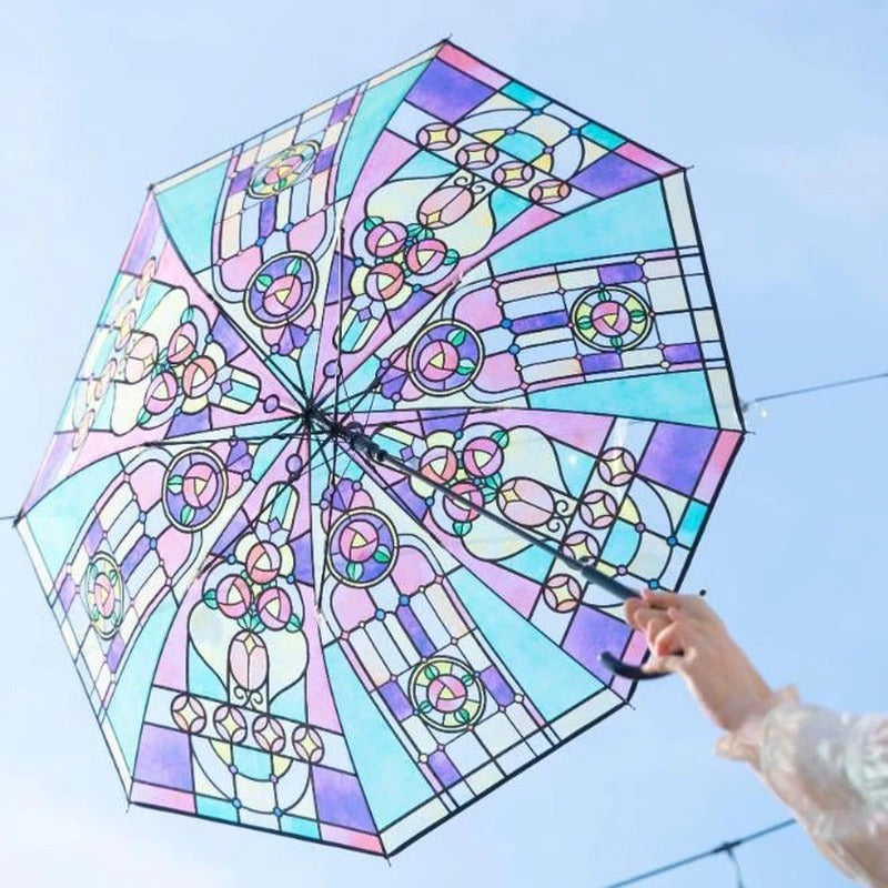 A person is holding an umbrella which looks like it is made from rainbow stained glass.