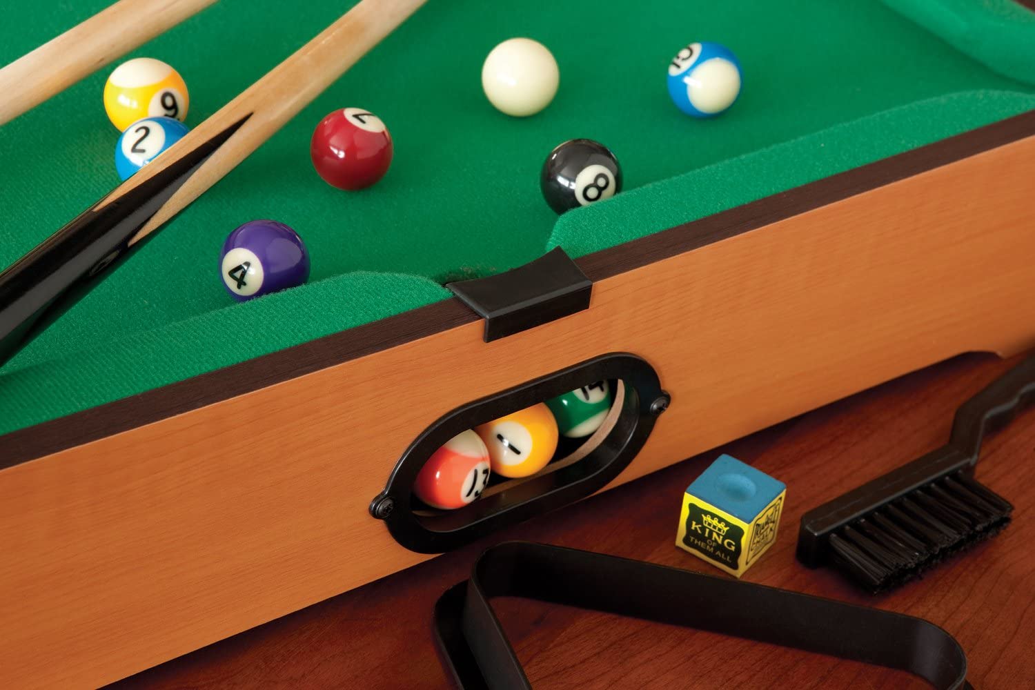 A close-up view of the automatic side ball return chute on a table-top size billiard game set.