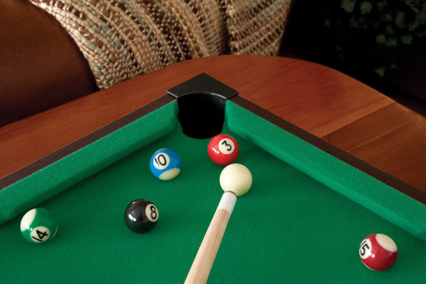 A close up view of a billiard cue stick aiming to sink a red ball 3 into a corner pocket. 