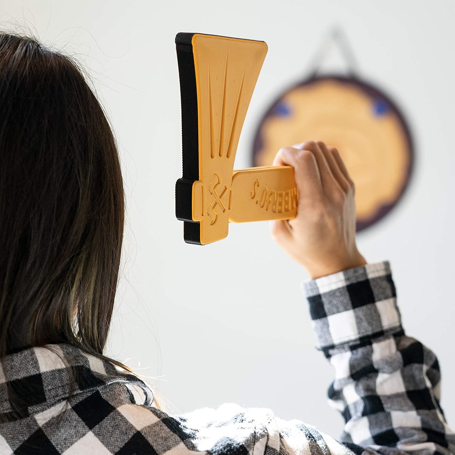 A person is about to throw a foam axe at a bullseye board.