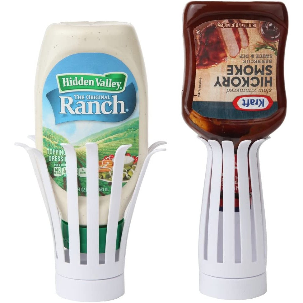 Two white upside-down condiment bottle holders to make dispensing sauce easier. One has a bottle of ranch sauce in it and the other a bottle of hickory smoke bbq sauce and dip.