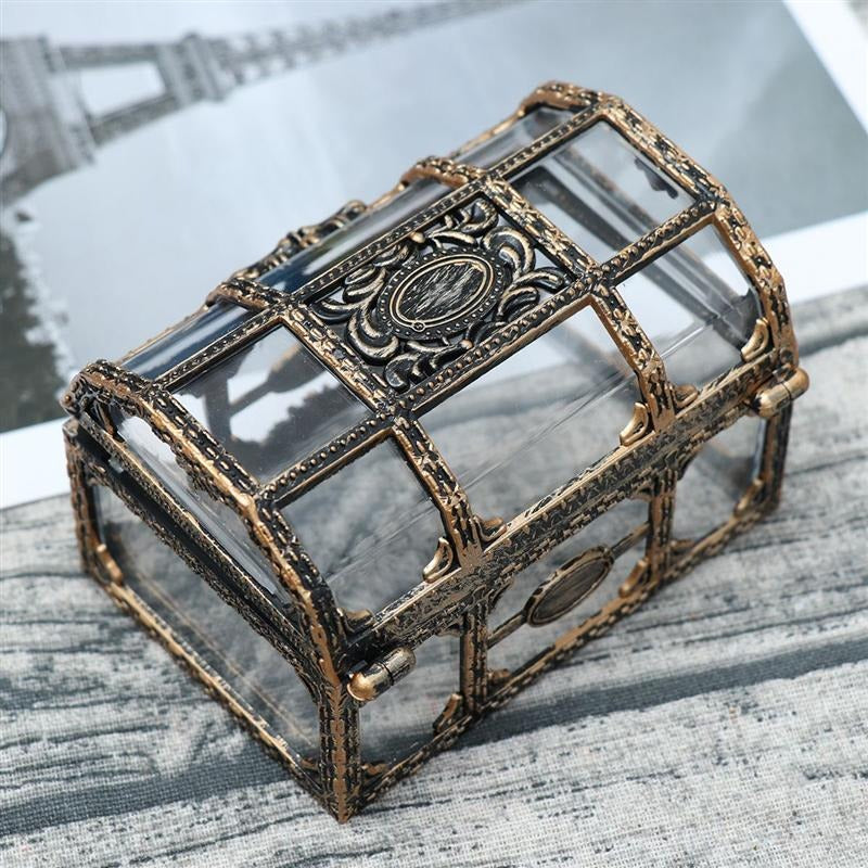 A vintage pirates treasure chest made from glass and metal which is used for storage.