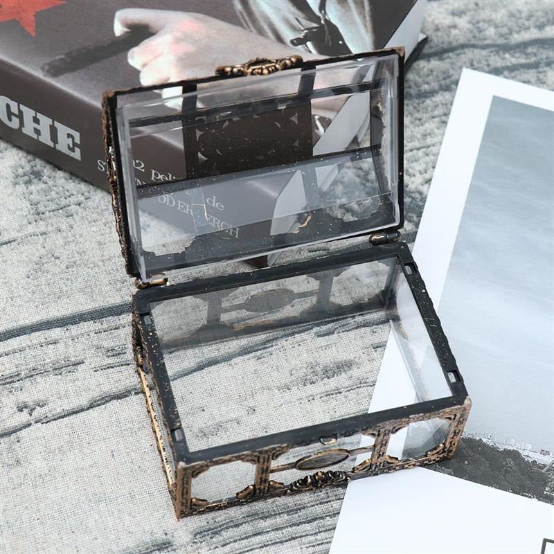 A small glass and metal pirates treasure chest made for storing small items.