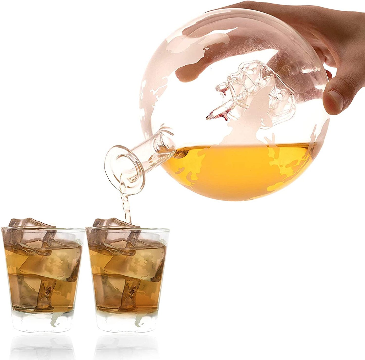 A hand is pouring whiskey out of a globe decanter into a shot glass. The world map is etched on the outside of the glass decanter.