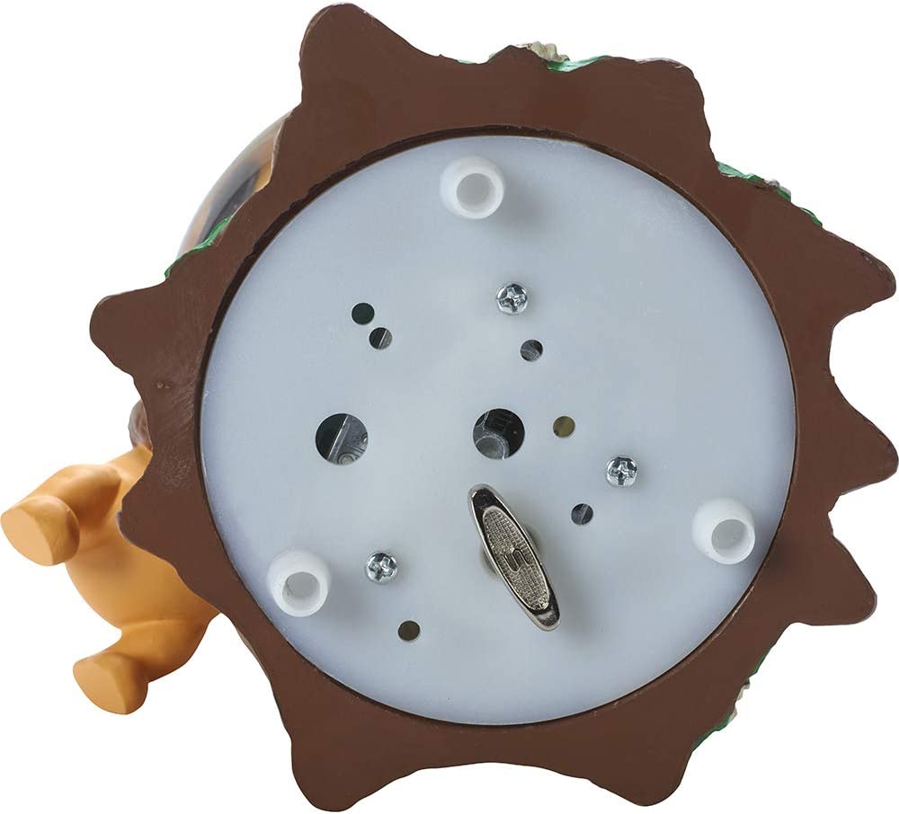 A view from underneath a Winnie the Pooh snow globe showing the battery compartment and the musical key to wind for the globe to play music.