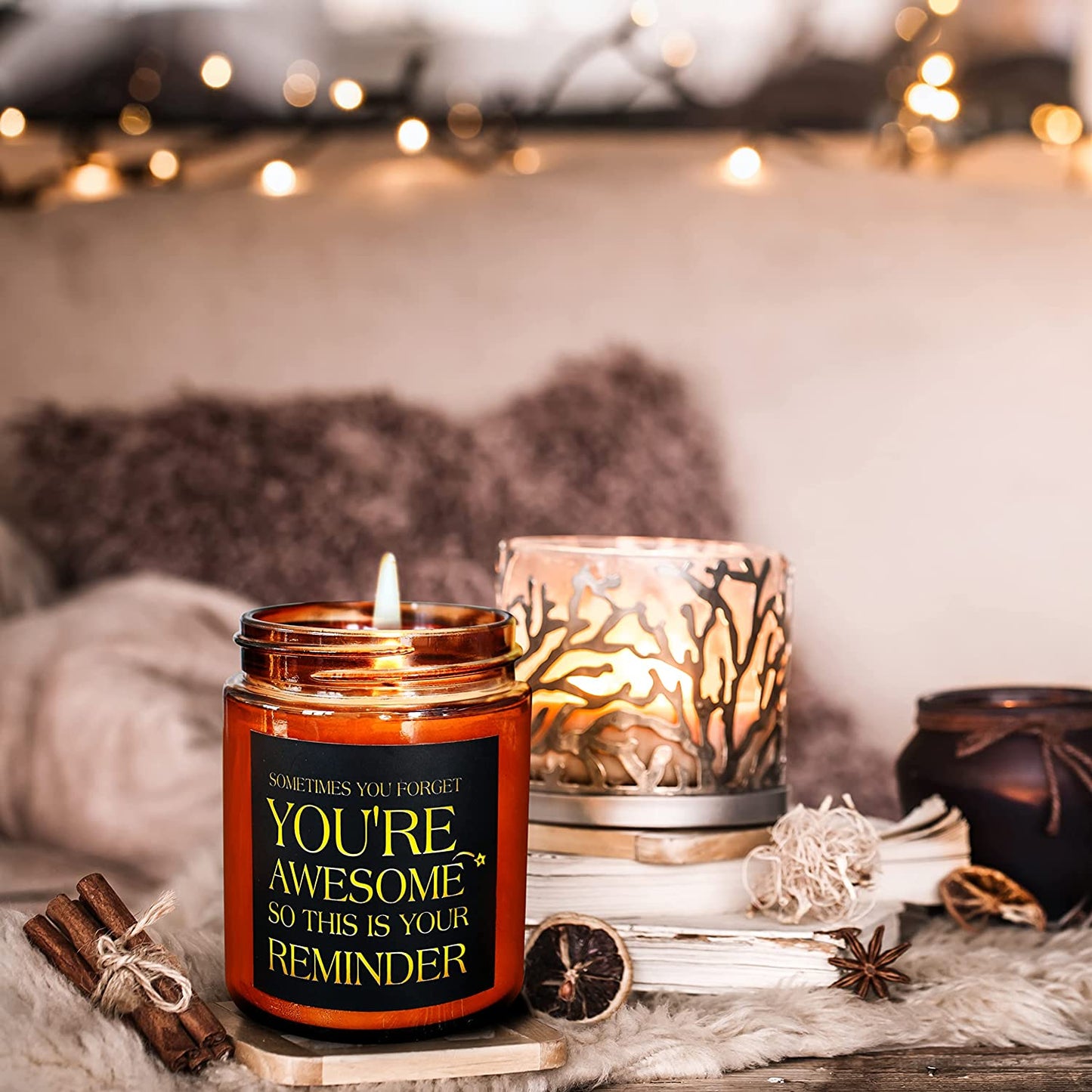 A lighted candle in a jar is on a table. It has a quote printed on it which says, "Sometimes You Forget You’re Awesome So This Is Your Reminder.”