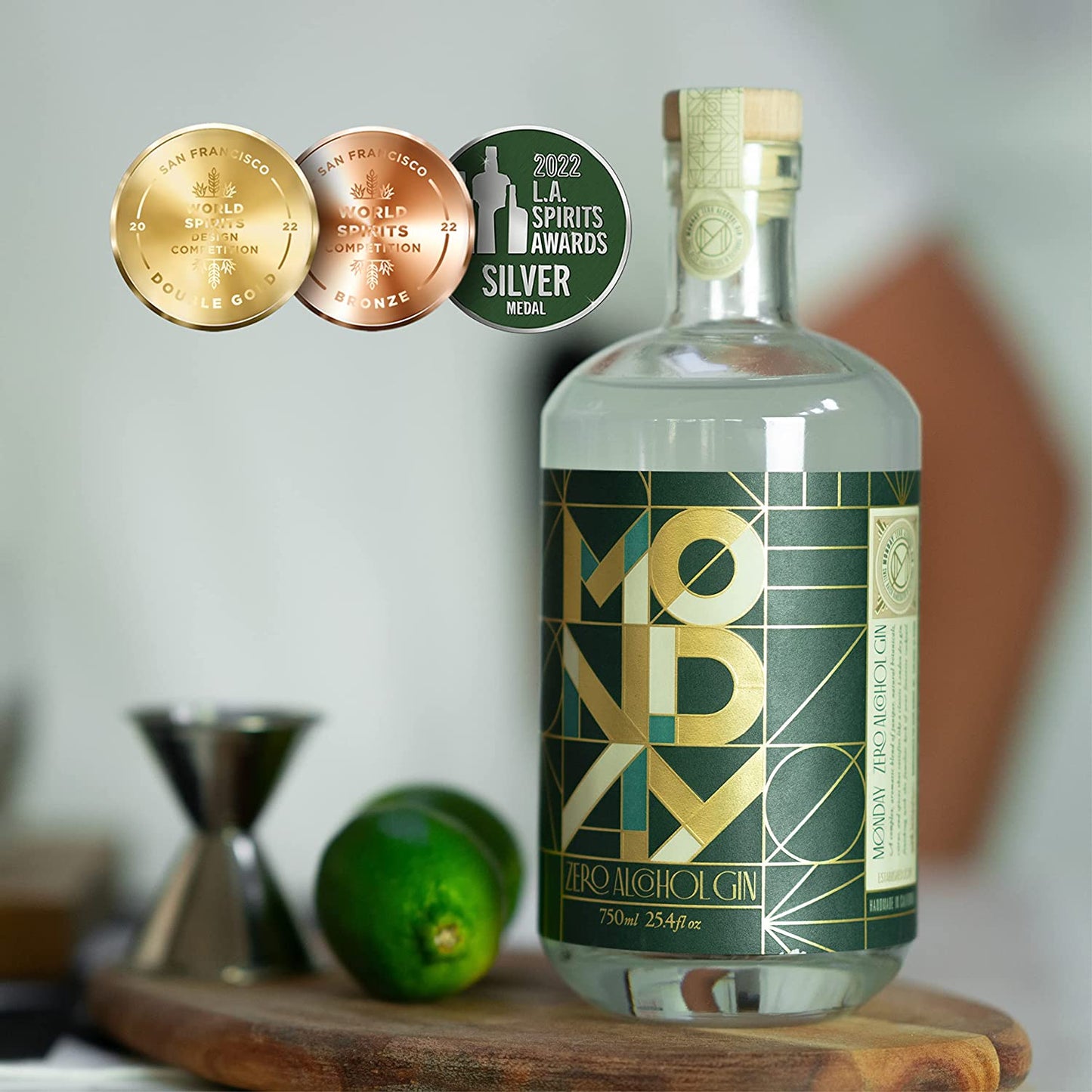 A bottle of zero alcohol Monday brand gin on a wooden table with fresh limes nearby.